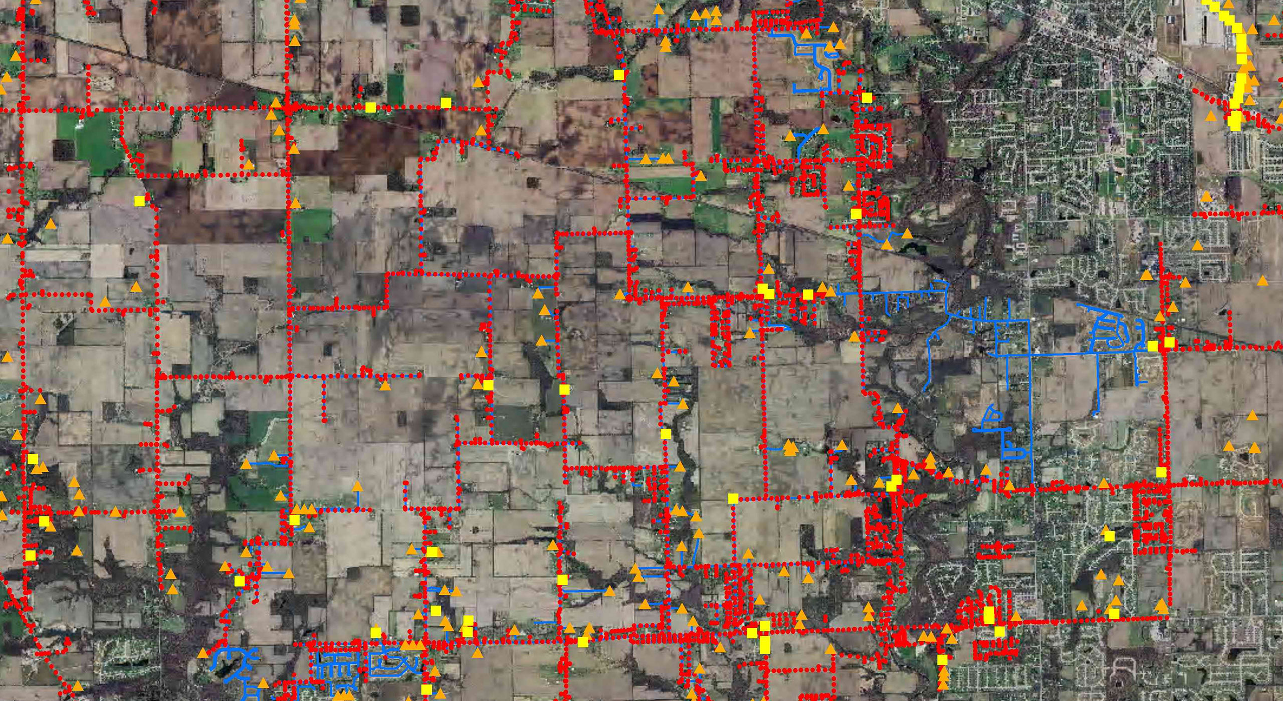 High-altitude view of a city with red lines and yellow dots illustrating the effectiveness of asset management systems.