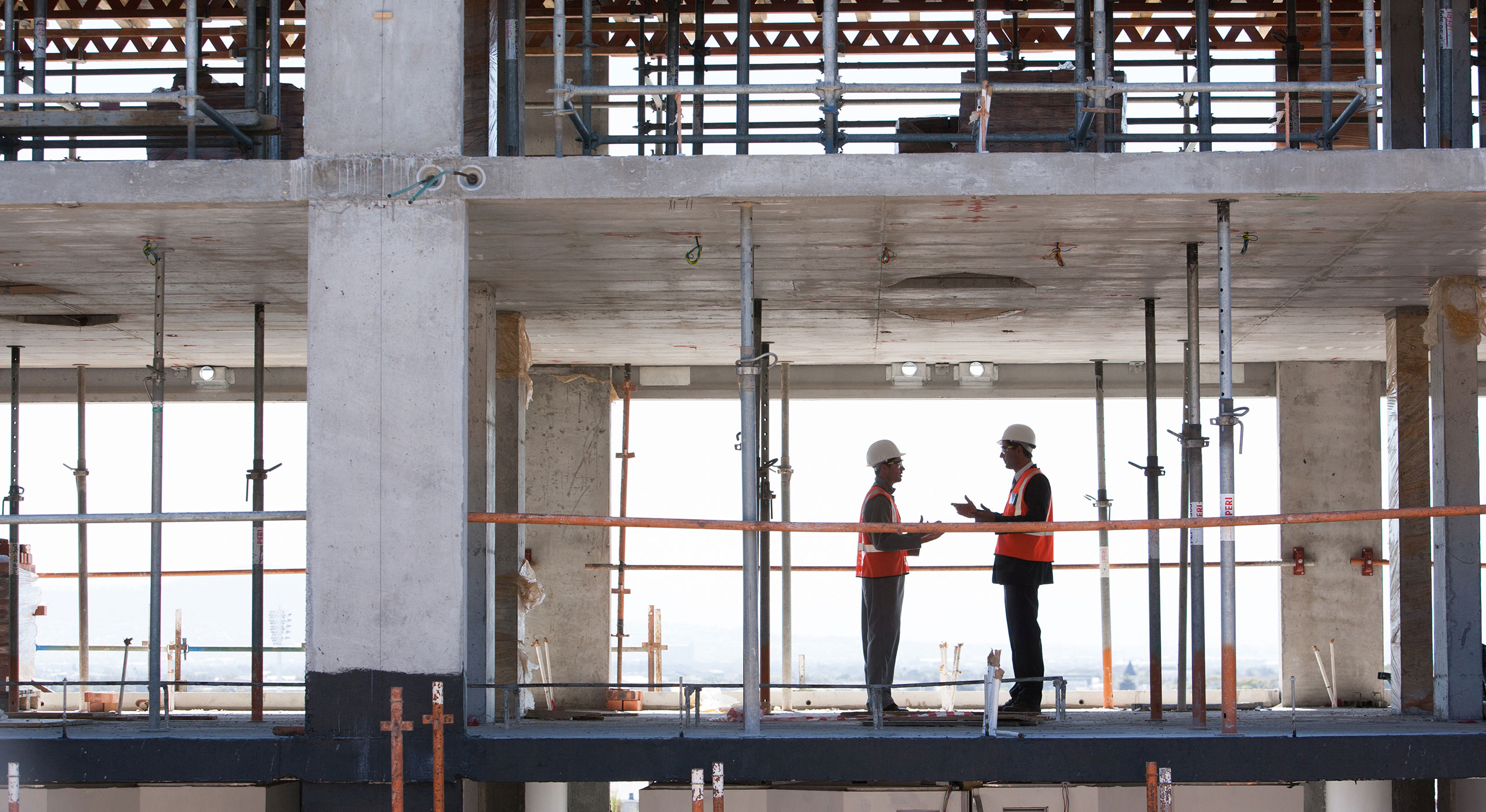Construction workers performing tasks inside a building under development as part of commercial construction services.