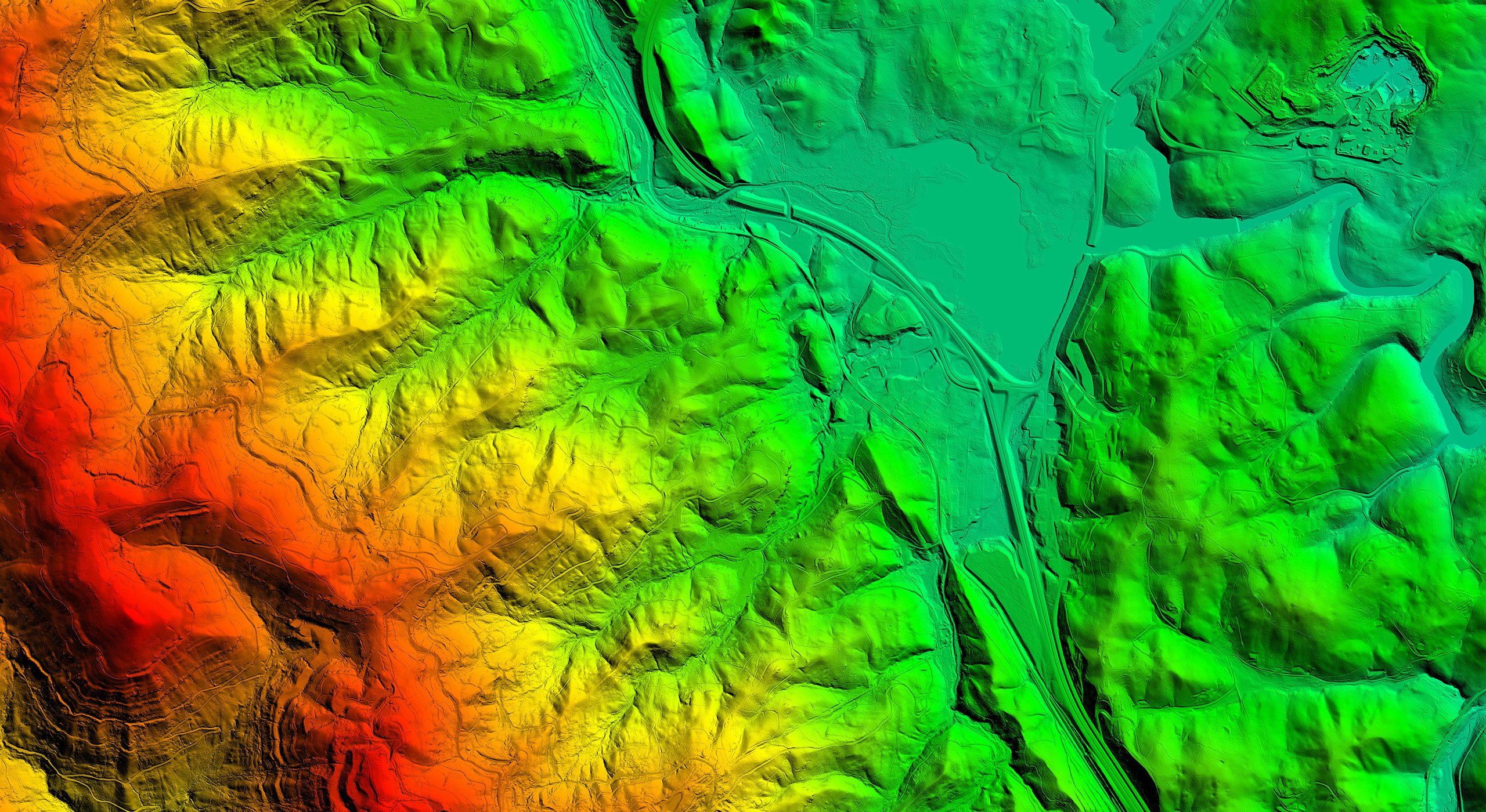 Multi-colored aerial lidar elevation map of mountains and a city in a valley.