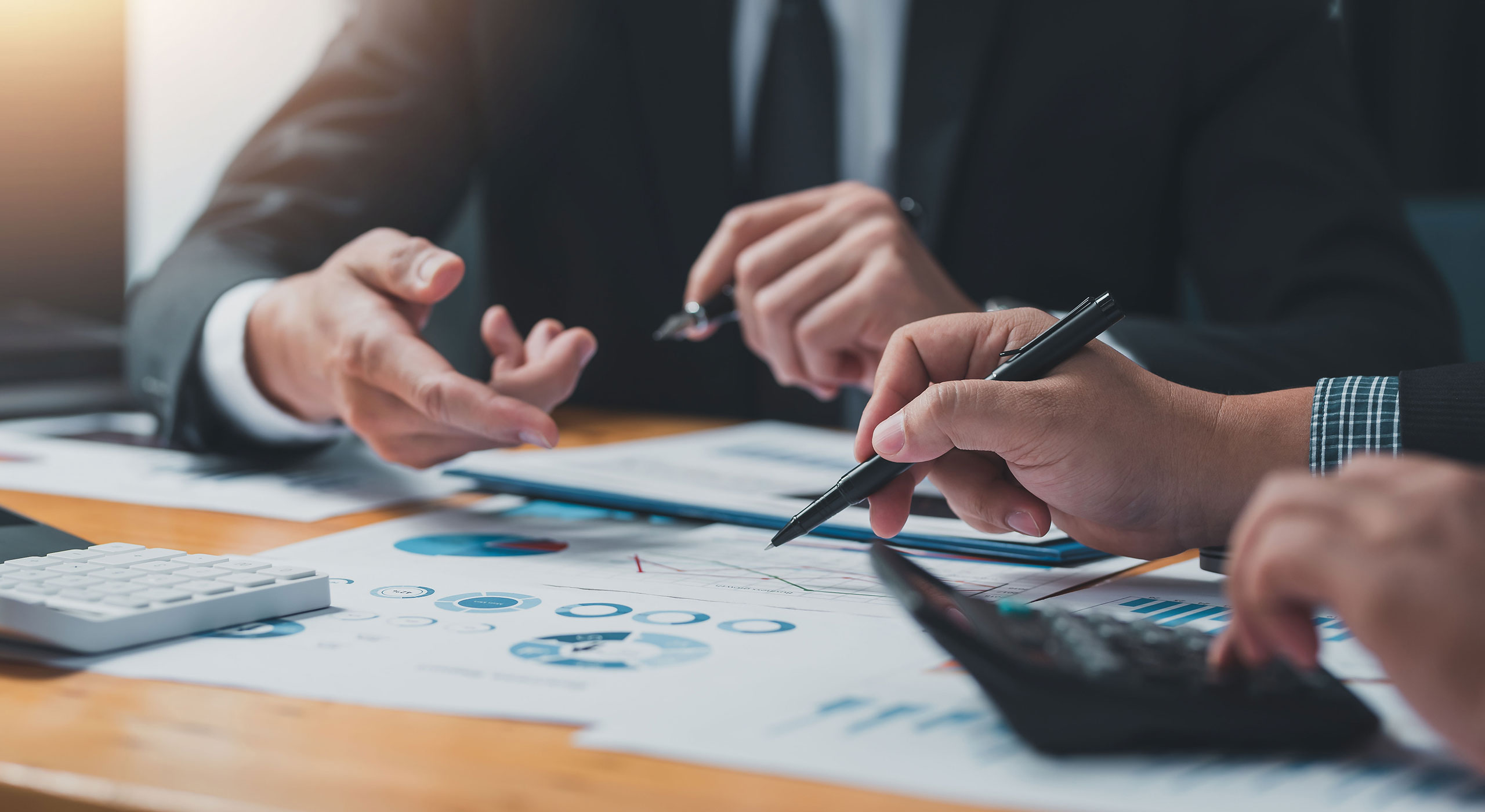 Two professionals discussing business strategies at a table with papers, representing collaborative strategic consulting.