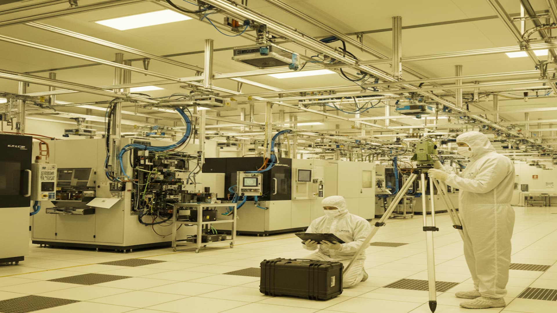 Surveyors conducting geospatial management tasks inside a semiconductor fabrication facility.