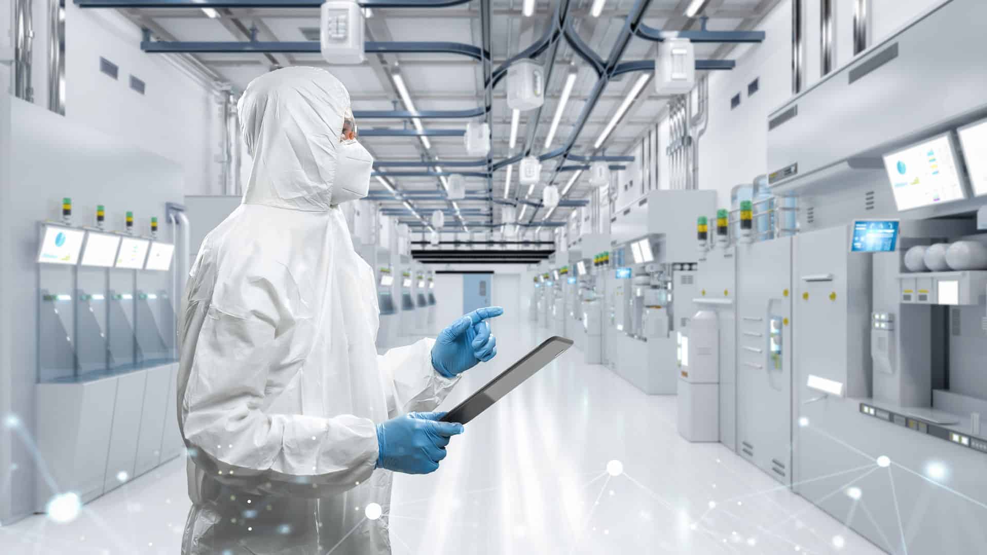 A technician in cleanroom gear uses a digital tablet inside a high-tech semiconductor facility, representing modernization needs in Pre-BIM fabs.